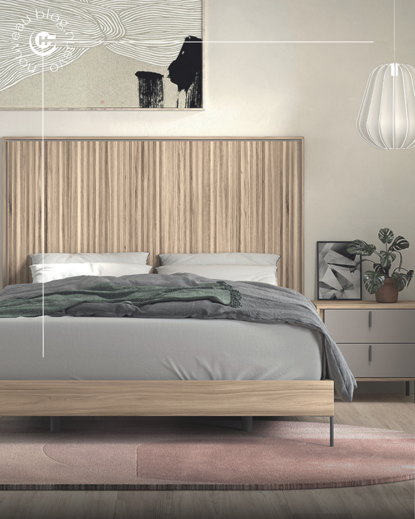 Dormitorio de matrimonio EMOTION con cama de diseño actual, cabecero de madera y mesita en tonos neutros.